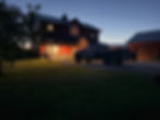 Evening on the homestead, with porch lights on, ducks in the yard, and a LandGuys truck parked in the driveway.