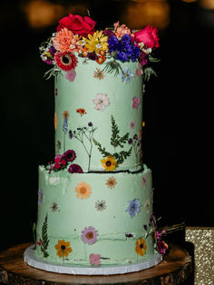 This teal cake with pressed florals and bold vibrant colors make for a beautiful statement dessert.