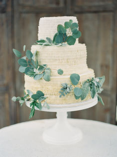 This wedding cake's icing has a soft sage green tint and is decorated with lovely eucalyptus and sage leaves.