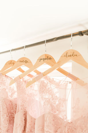 Four pale pink bridesmaids dresses hang elegantly with beautiful light pouring in through the windows at Spotswood Lodge. 