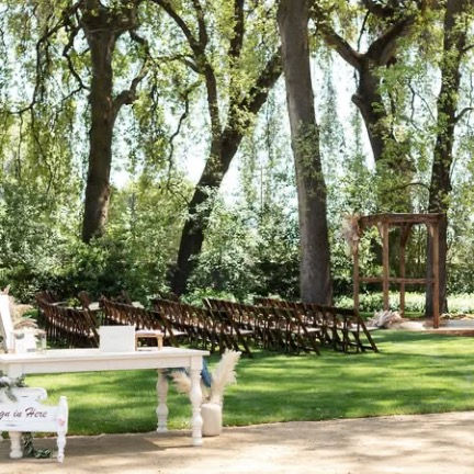 Outdoor wedding ceremony setup with chairs and arch