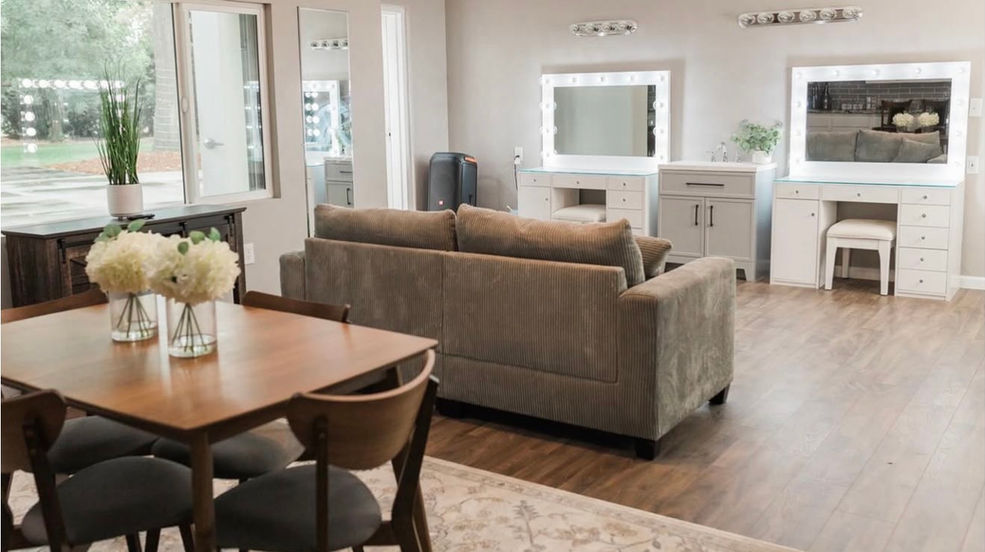 Living room with dining table, sofa, and vanity areas