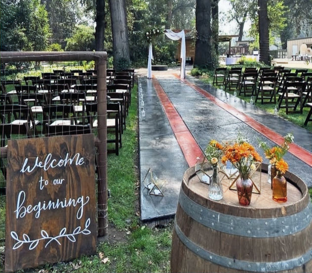Outdoor wedding aisle with sign 'Welcome to our beginning'