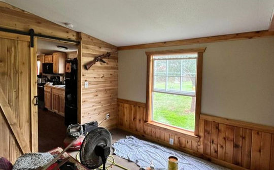 Wood-paneled room with window and barn door