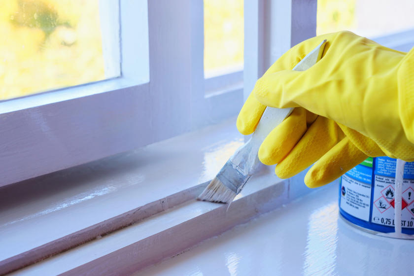 gloved-hand-paints-window-trim-glossy.webp