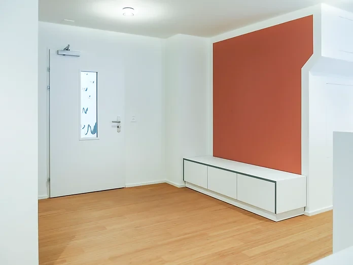 Arztpraxis, Eingangsbereich mit Sitzbank auf Mass durch Schreiner, Wandfarbe terrakotta, Bambus Parkettboden, Gestaltungs- und Farbkonzept, Planungsunterstützung Behandlungszimmer, Warteraum, Empfangzone, Garderobe und Pausenraum: Patricia Leforestier, Basel, Schweiz