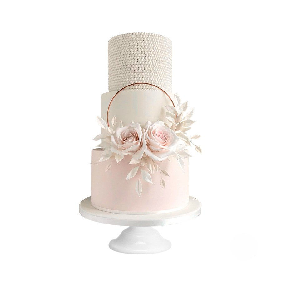 Pastel de Quince Años de tres niveles en tonos nude con flores en azúcar y textura tipo perla en la parte superior.