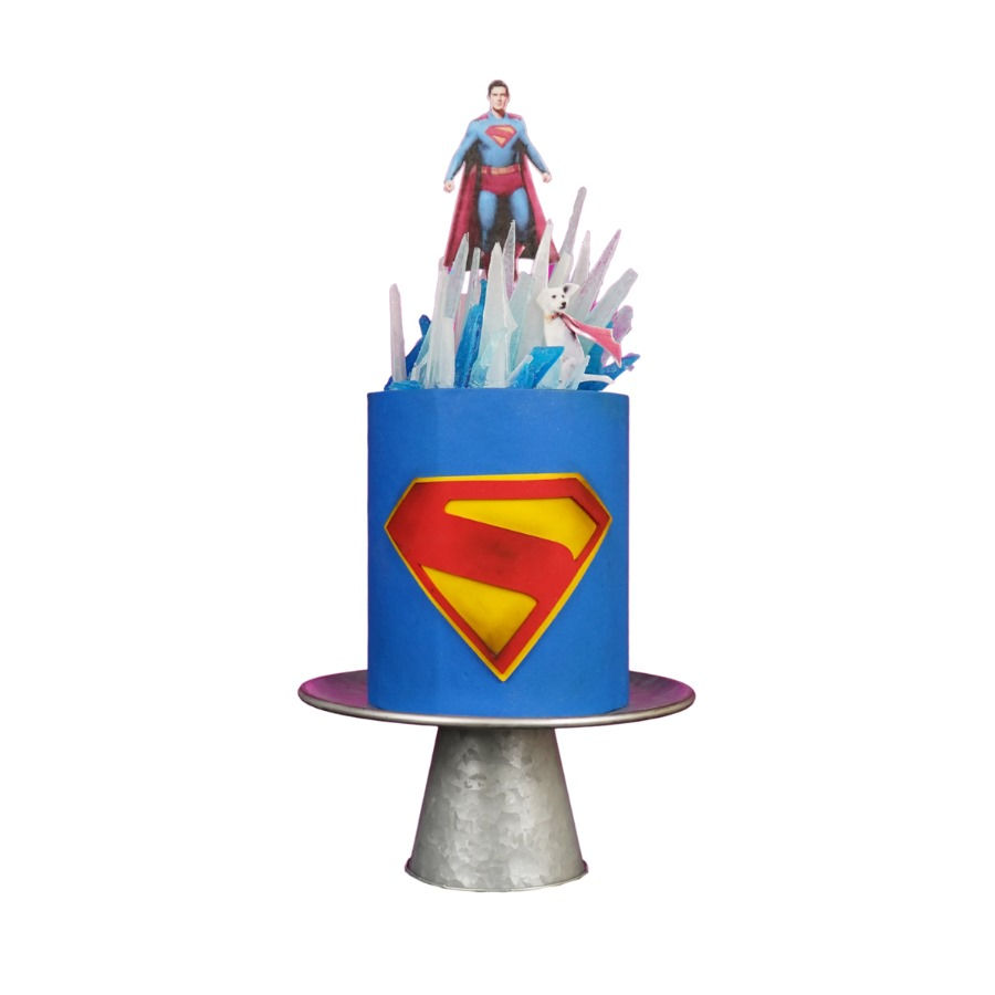 Pastel de cumpleaños de Superman en tonos azul intenso con el icónico emblema en relieve al frente.
