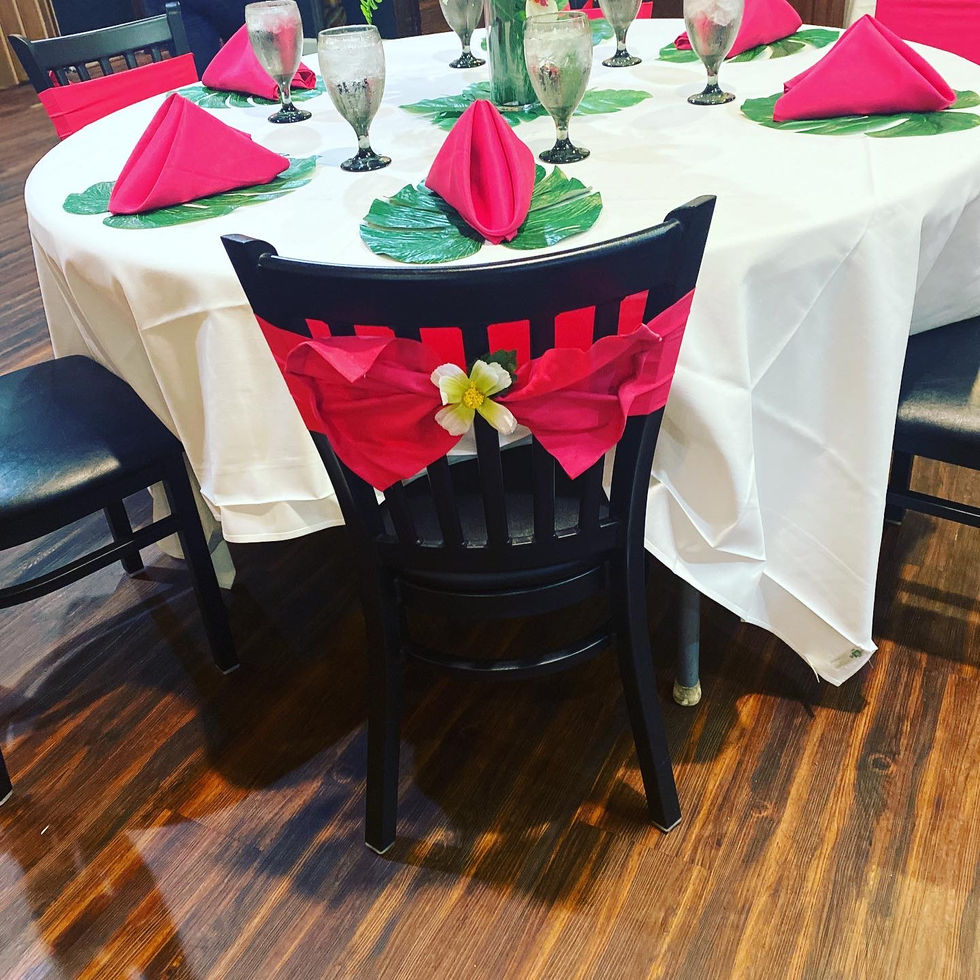 Floral chair sash with palm leaves and pink napkin folds for a tropical tablescape by MoByDsign.