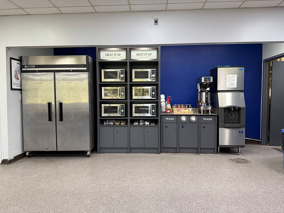 Modern office breakroom design with stainless appliances.