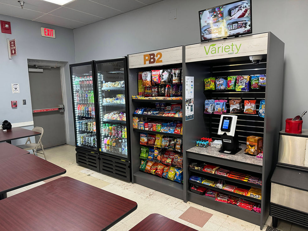 PB2 Foods micro market with branded headers, beverage coolers, snack shelving and a self-checkout kiosk