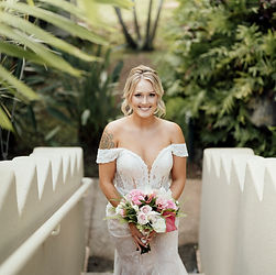 Happy bride on stairs with wedding bouquet