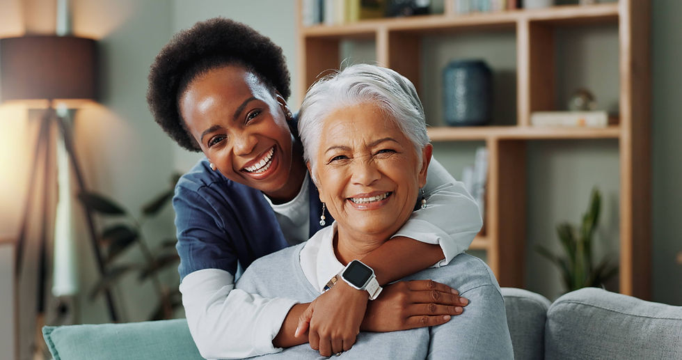 Smiling African American nurse hugging an older Hispanic woman during a compassionate healthcare visit at a Community Health Center.