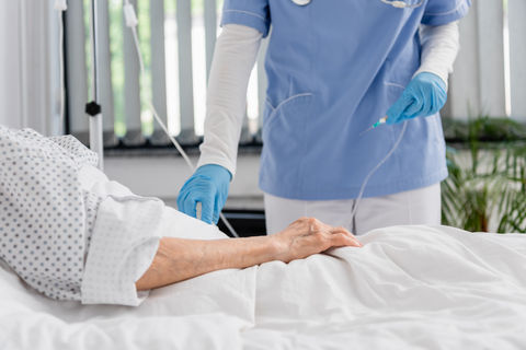 Cropped view of nurse holding catheter near senior woman on hospital bed.jpg