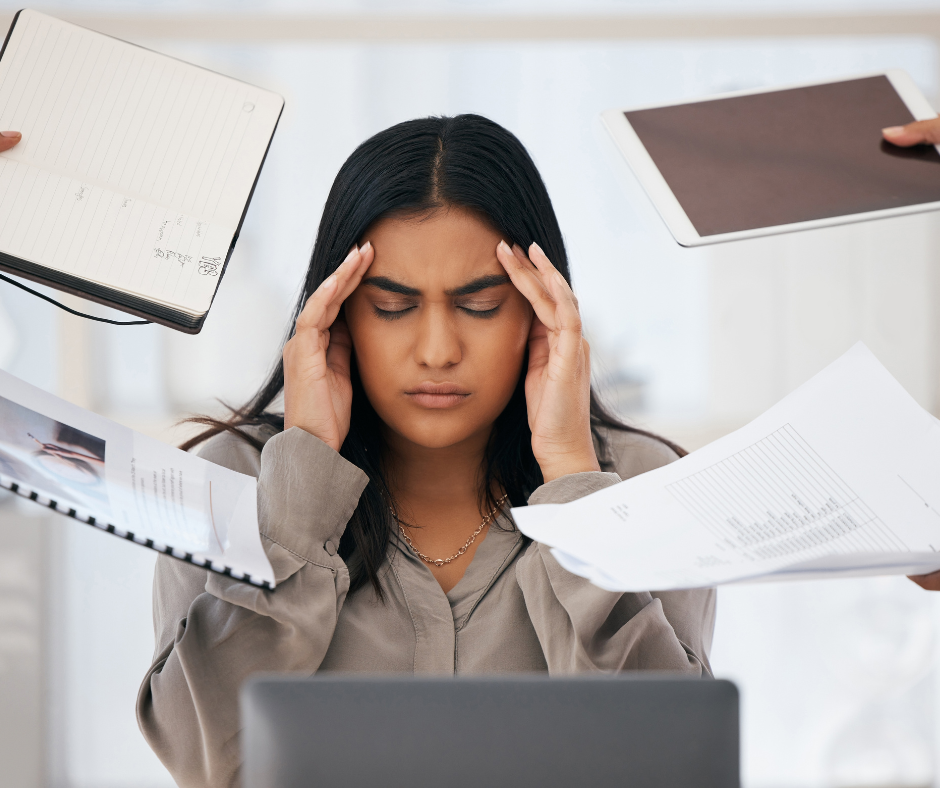 Woman holding coffee cup looking mildly worried while looking at a computer screen