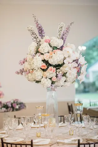 A tall pastel floral centerpiece with table decor for a wedding reception at A Thousand Oaks Events in Cypress, TX