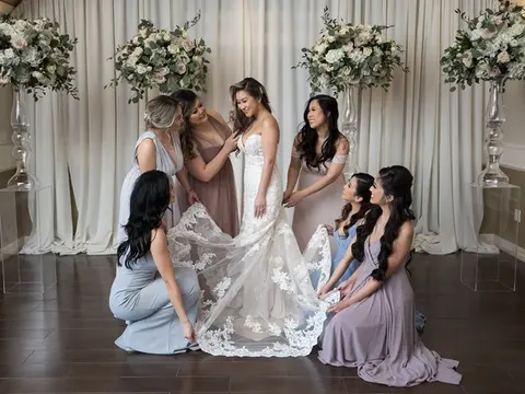 A bride and her bridesmaids admiring her dress at The Bougainvilleas Venue in Houston, TX