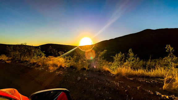 The sun dropping behind the hills on the road out of Young