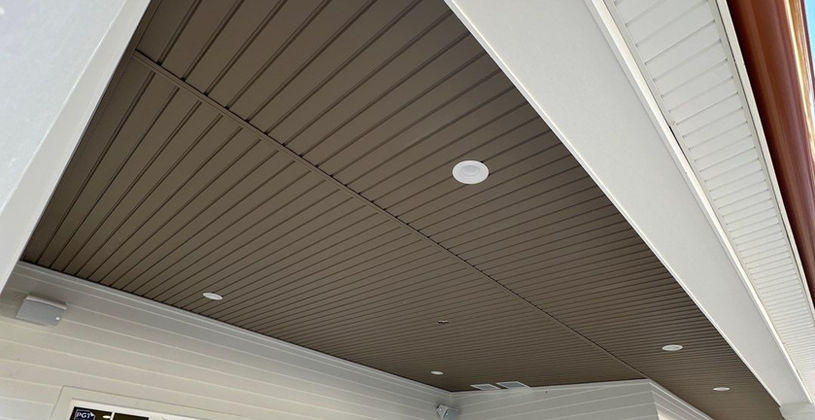 Modern home exterior with dark wood slat porch ceiling