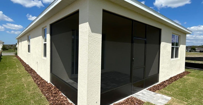 Modern screened-in patio addition on a stucco home