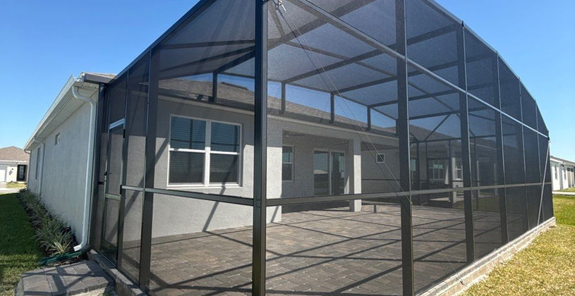 Large screened-in patio enclosure on a residential home.