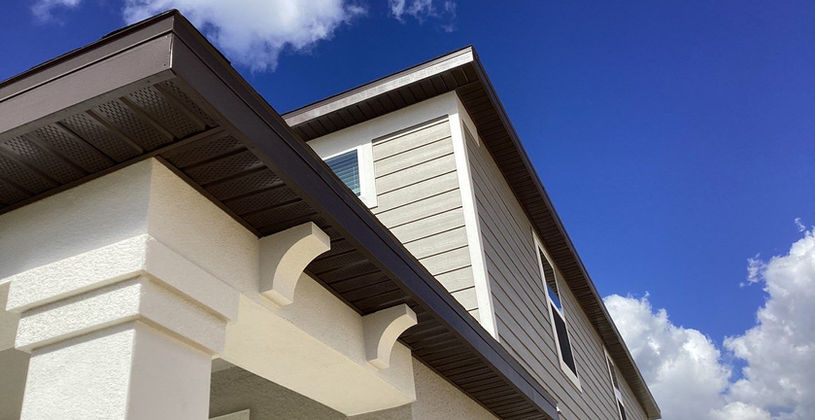 Low angle view of a modern house exterior under a blue sky.