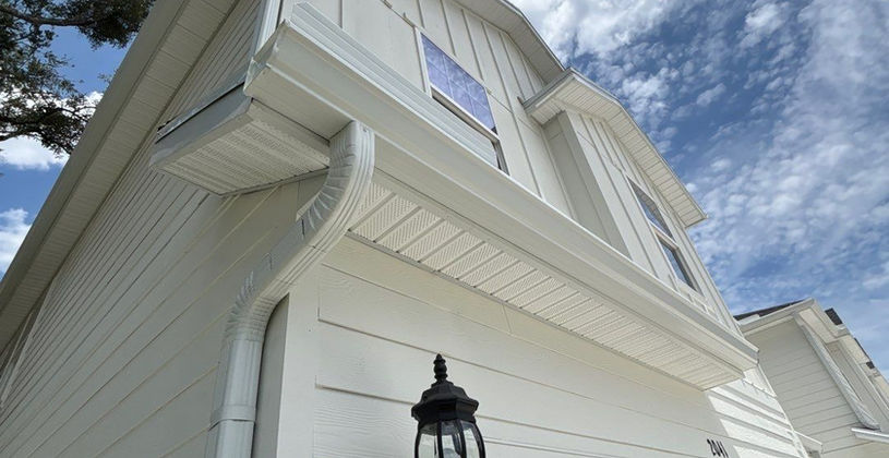 White two-story house with a black outdoor wall lamp