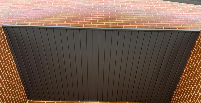 Modern brick building corner with contrasting grey siding