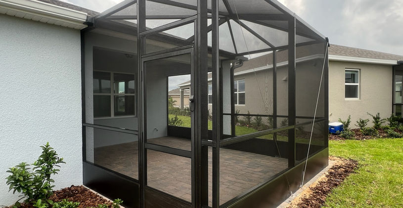 Modern black screened-in patio enclosure on a house back yard