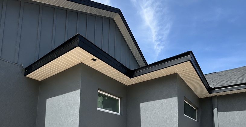 Modern grey house with black trim under a clear blue sky