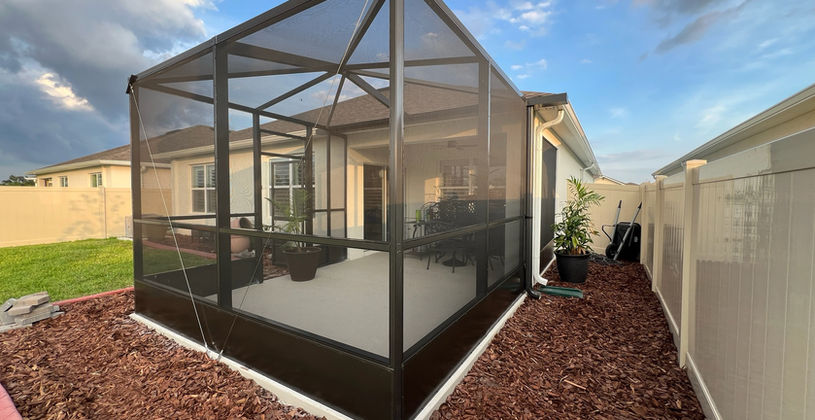 Modern screened-in patio enclosure in a residential backyard