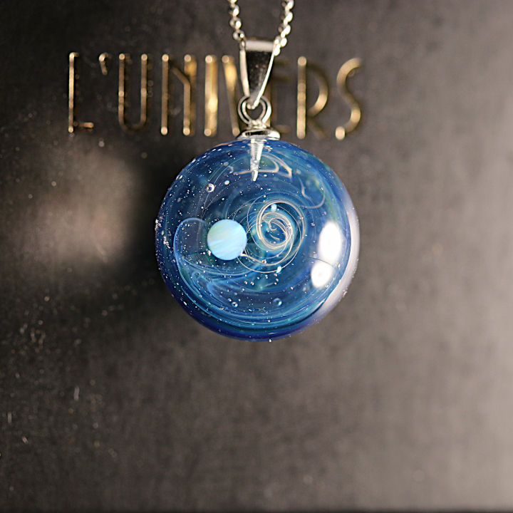 pendentif galaxie avec une voie lactée bleu et une planète Lune en apesanteur dans la voie lactée.