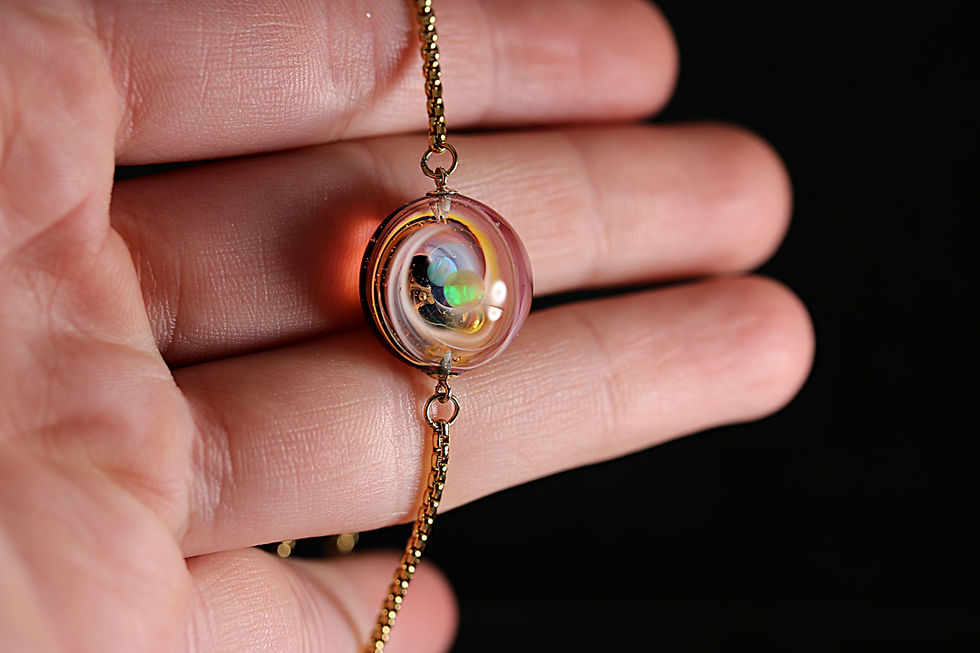 Thumbnail: bracelet galaxie avec une voie lactée orange et deux planètes en apesanteur. 