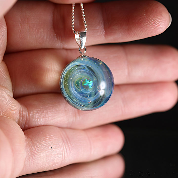 Miniature : bijoux galaxie posé sur une mains. 