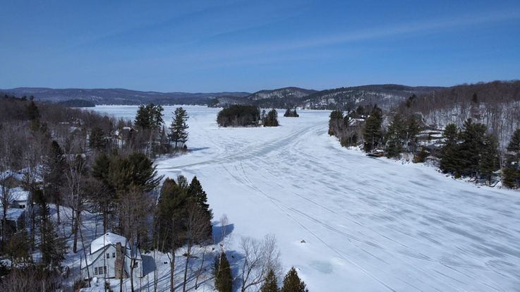 Vue aérienne drone du lac gelé de l’Achigan en hiver à Saint-Hippolyte, Québec, Canada