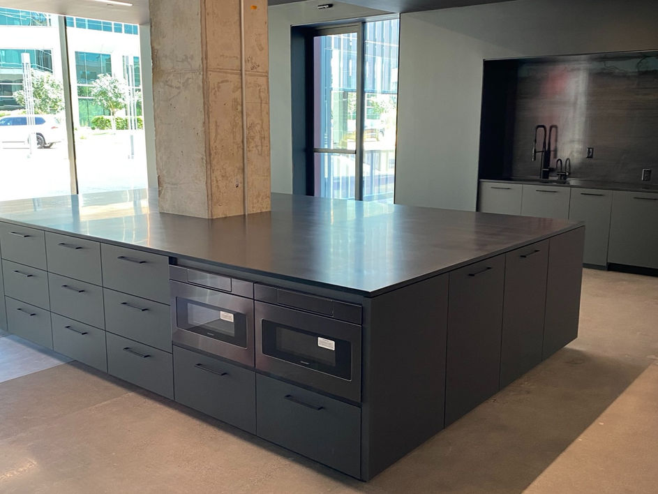 Black Velvet Cabinetry and Countertops in a Commercial Office Space.
Custom cabinets with black velvet faces installed around an existing concrete column. Integrated with black solid surface countertops.