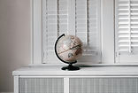 globe in front of window shutters