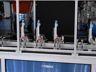 Robot lineal de un eje Yamaha PHASER moviendo una pieza en una transferencia industrial de largo recorrido.