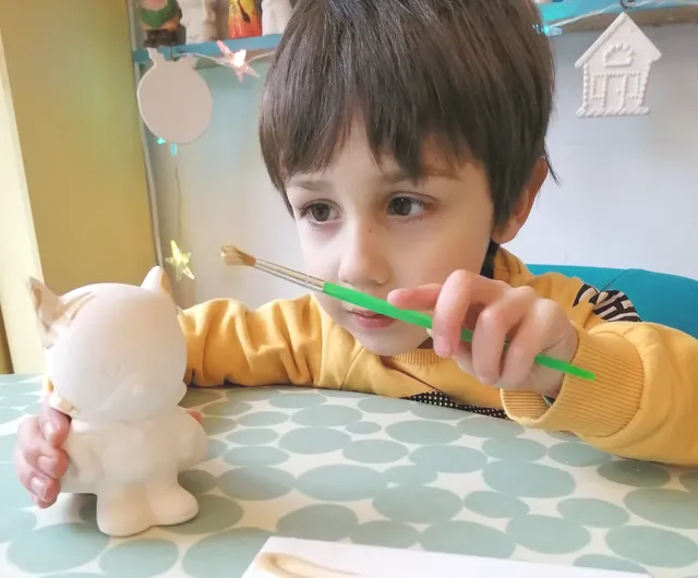 young boy painting a ceramic object at Doodles Ceramics Edinburgh