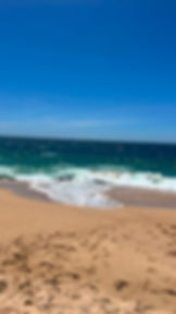 Paraíso Yoliztli: playa de arena, olas azules y cielo.