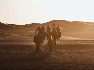 Kamelreiten in der Sahara bei Merzouga, Marokko – Kamelkarawane beim Sonnenaufgang in den Sanddünen des Erg Chebbi