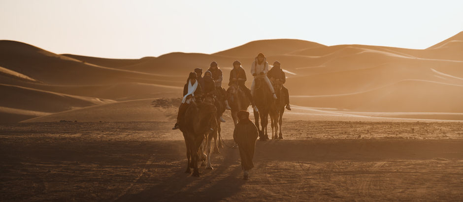Kamelreiten in der Sahara bei Merzouga, Marokko – Kamelkarawane beim Sonnenaufgang in den Sanddünen des Erg Chebbi