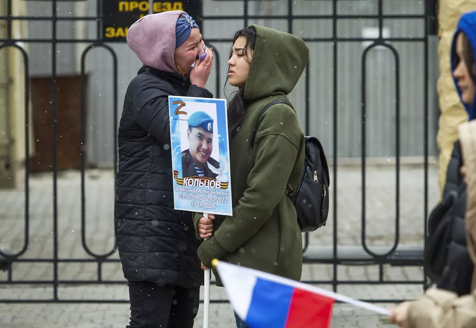 Deux femmes en pleurs tiennent le portrait d’un militaire russe tué lors des combats en Ukraine, à Oulan-Oudé, en Bouriatie. Photo AP