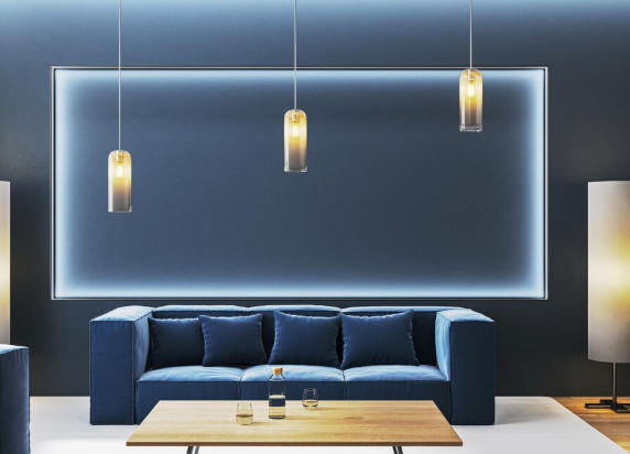 Modern living room with a blue sofa, wood table, and a bottle with two glasses. Three pendant lights hang above, creating a cozy vibe.