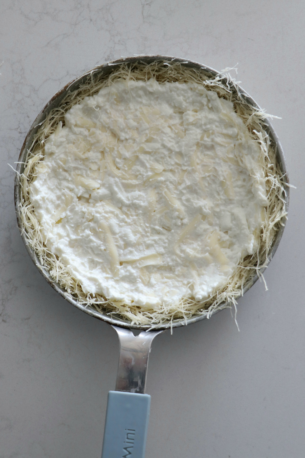 מורחים שכבה של תערובת הגבינות מעל האיטריות