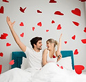 Young happy couple sitting on the bed, t