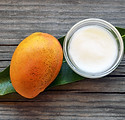 Mango body butter in a glass bowl and fr