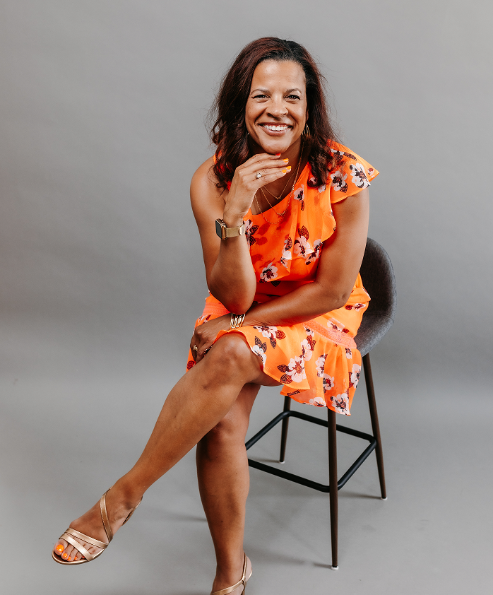 Crsytal Duncan smiling in orange blouse.