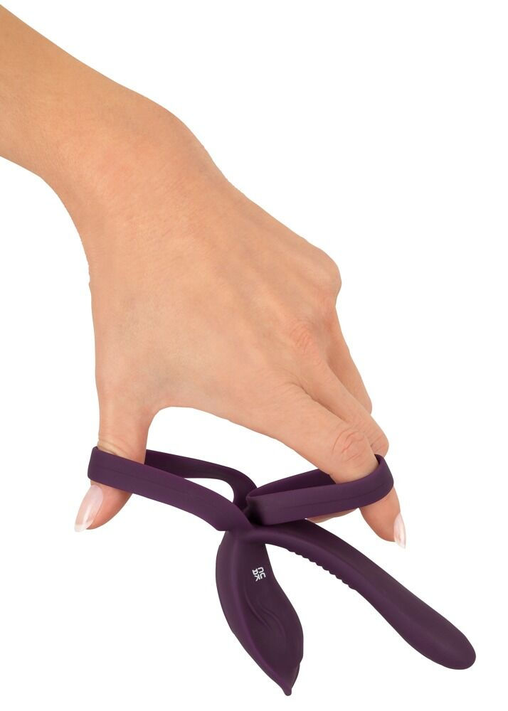 Miniaturbild: fernsteuerbarer Paarvibrator mit Penis- und Hodenring und Klitorisreizer. Frauenhand demonstriert Flexibilität der Ringe