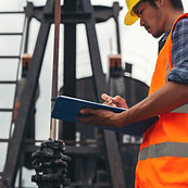 workers-standing-checking-beside-working-oil-pumps.